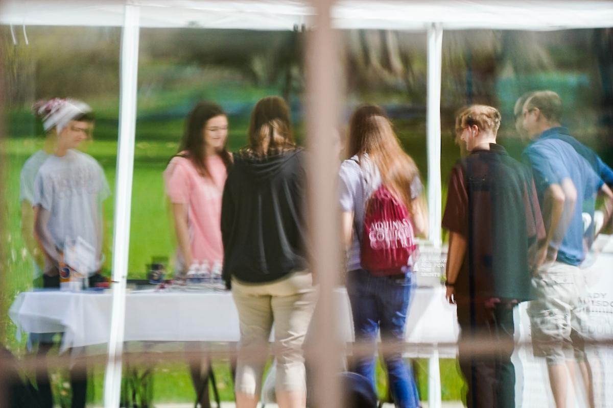 Reflection in window of students standing at a table